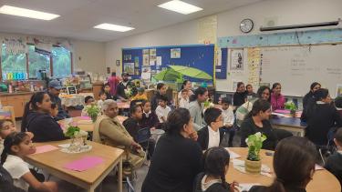 Dave Kandal - Parent Partnerships Classroom filled with students and family members sitting in chairs listening to a presentation.