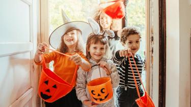 iStock Image - Halloween Children in Halloween costumes at the door entrance of an old house